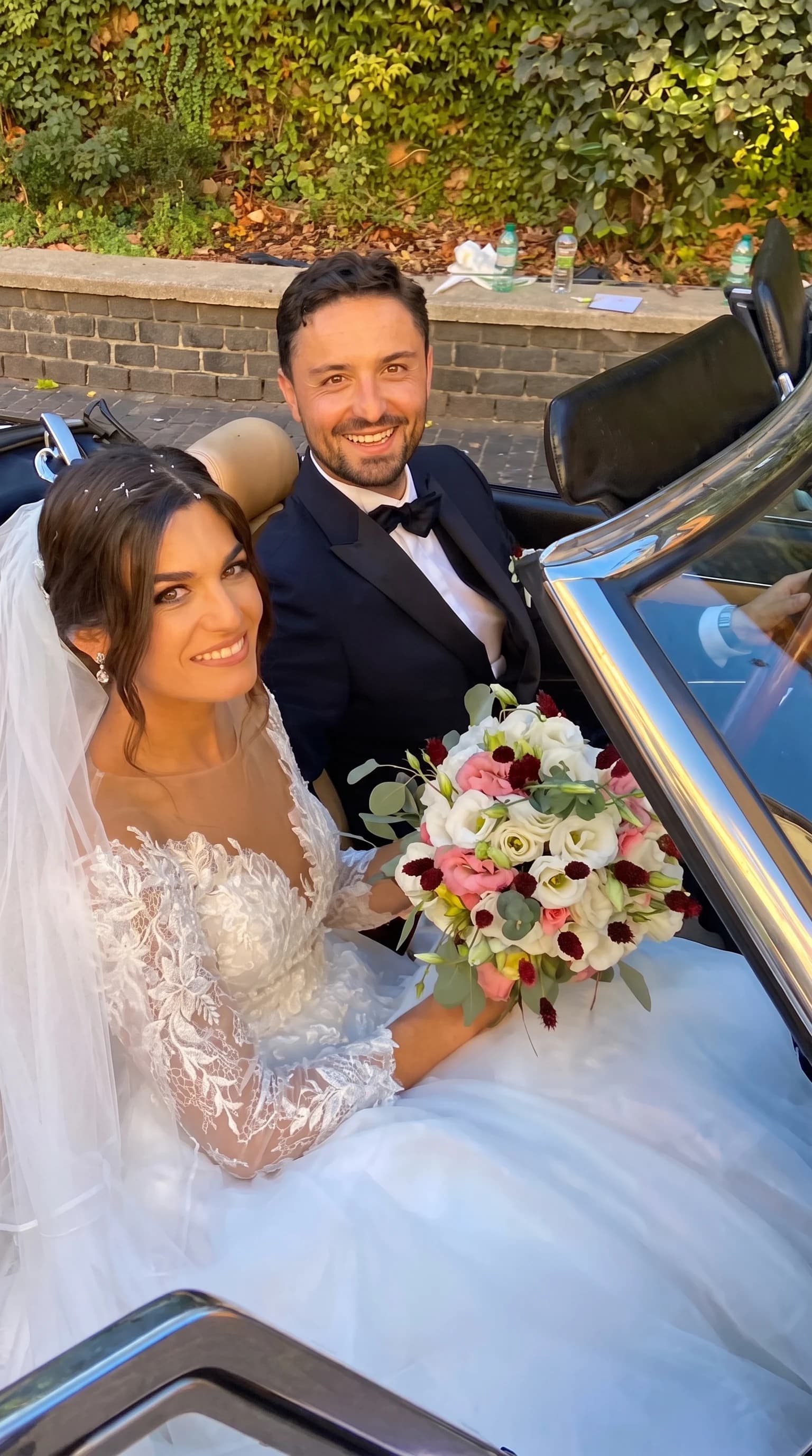 Sposa con bouquet di rose bianche, fiori rosa e bacche rosse